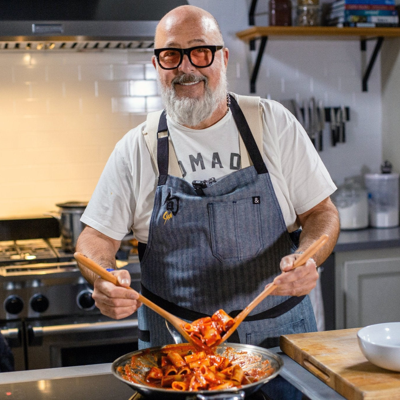 Andrew Zimmern of the Food Network cooking pasta in a kitchen.