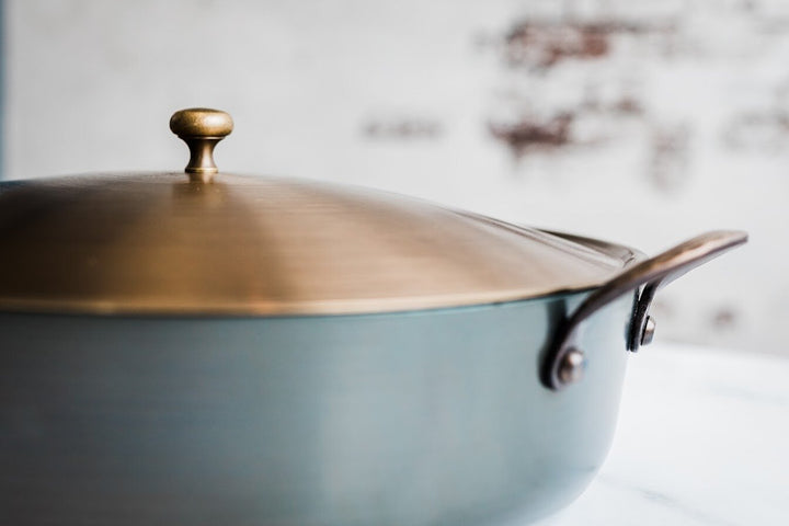 Handcrafted carbon steel rondeau with bronze handles and stainless steel lid