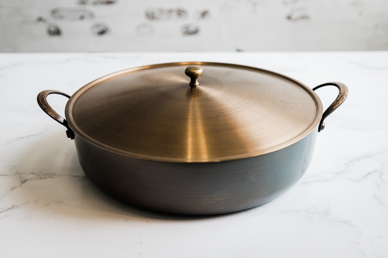 Handcrafted carbon steel rondeau with bronze handles and stainless steel lid