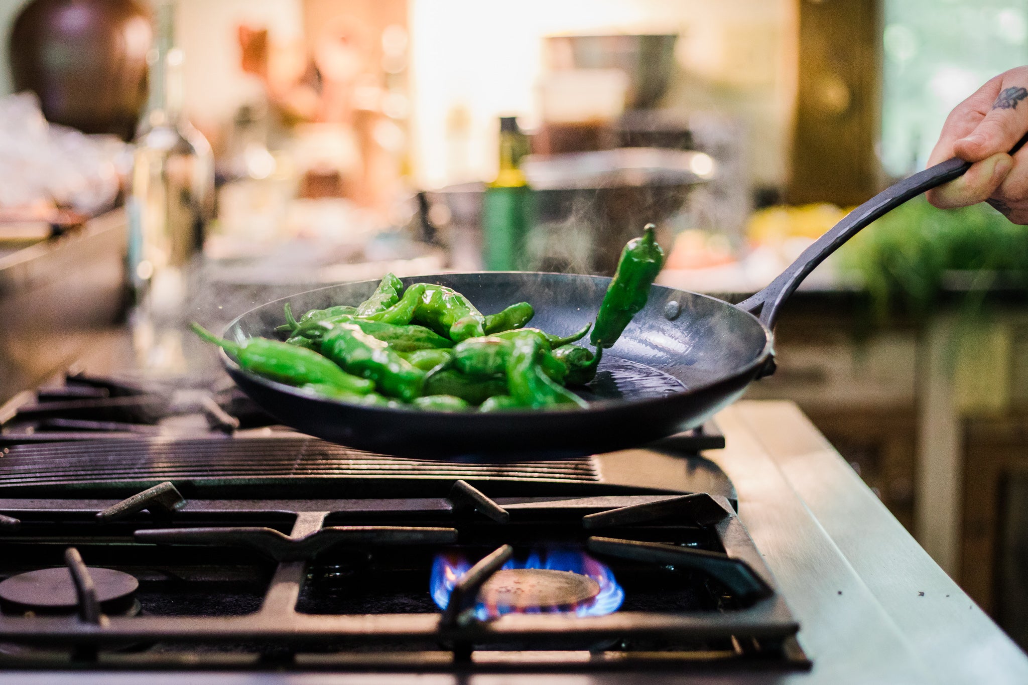 Chef saute peppers in a handmade, artisan skillet