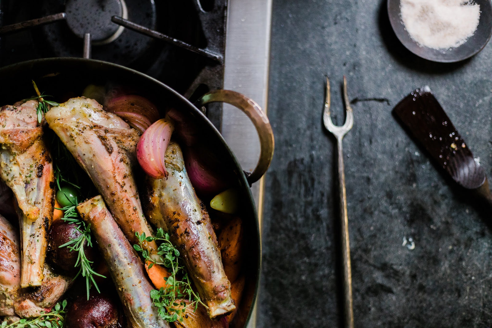 Hand forged rondeau pot holding meat and vegetables
