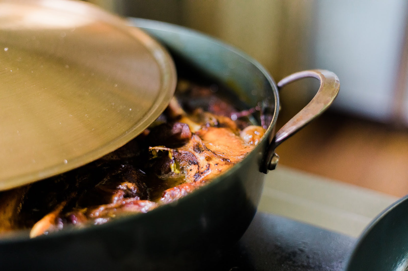Hand forged carbon steel rondeau with simmering foods inside