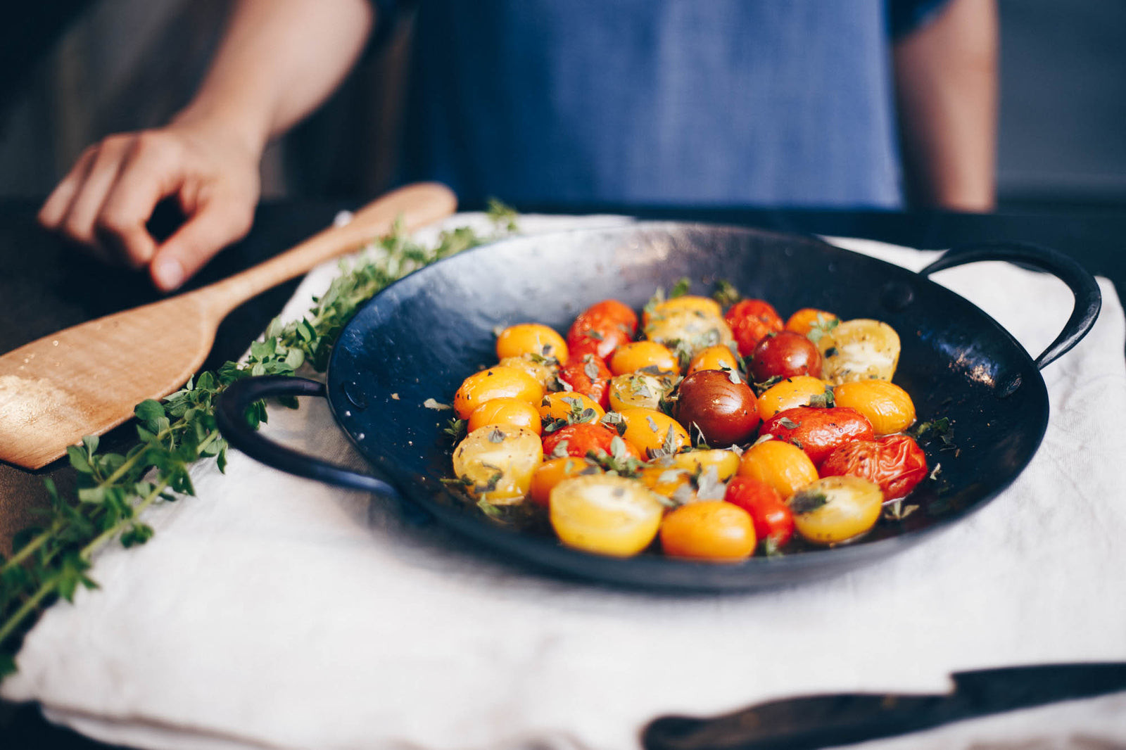 Hand forged, artisan carbon steel saucier with cooked multi-color tomatoes in it