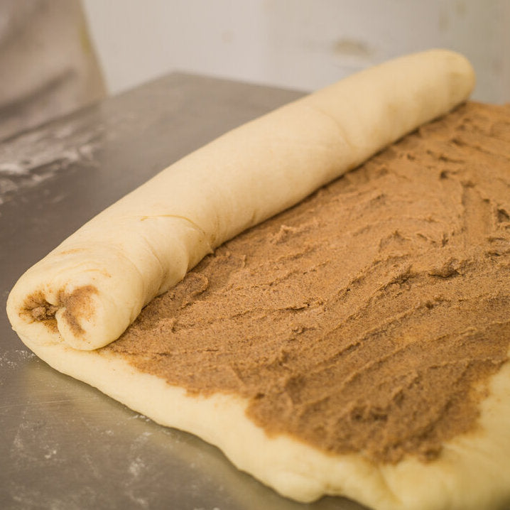 dough with cinnamon sugar filling being rolled up
