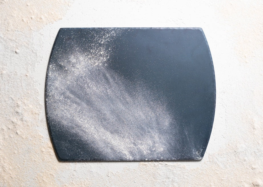 A handmade, hand forged steel bakeware sheet powdered in flour