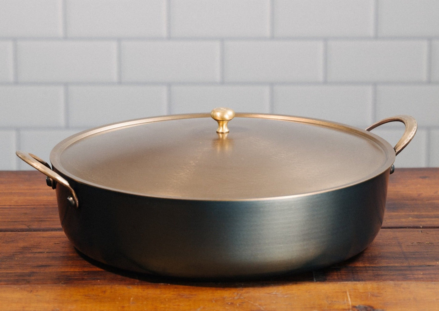 Handcrafted carbon steel rondeau with bronze handles and stainless steel lid