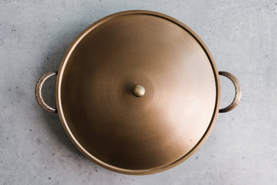 Handcrafted carbon steel saucier with bronze handles and stainless steel lid